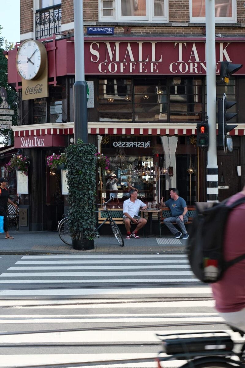 facade of Small Talk Coffee Corner in Amsterdam with people walking and biking by