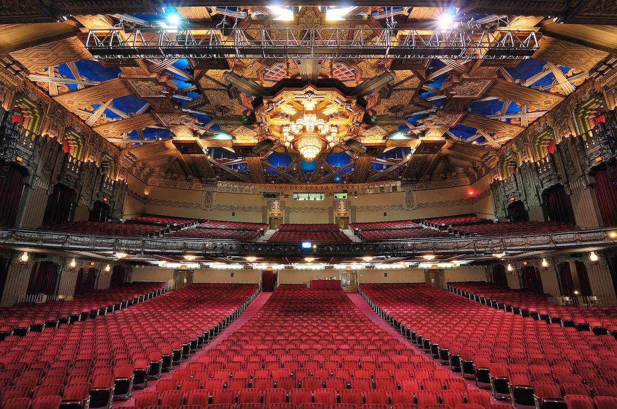 red seats underneath a giant chandelier inside the Hollywood Pantages Theatre in Los Angeles, California