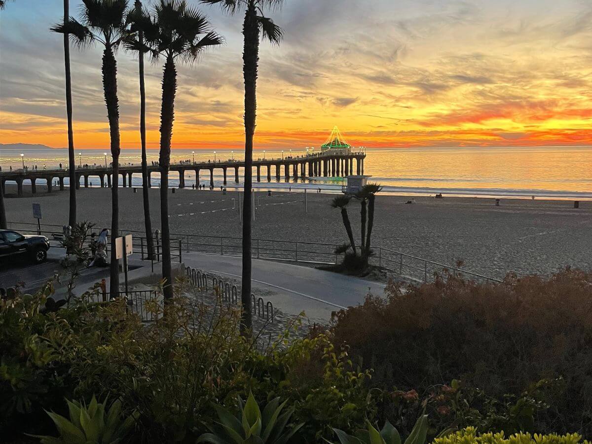 yellow and orange sunset glowing brightly over the Manhattan Beach Pier in Los Angeles, California