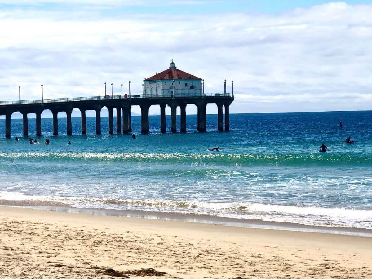 waves lapping up against the golden sand shore of Manhattan Beach in Los Angeles, California