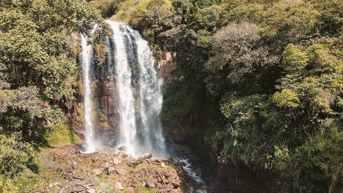 Drone shot of Cascada Silencio in Baños, Ecuador, featuring a stunning waterfall surrounded by lush greenery, ideal for solo travelers exploring Ecuador and creating unforgettable impressions.