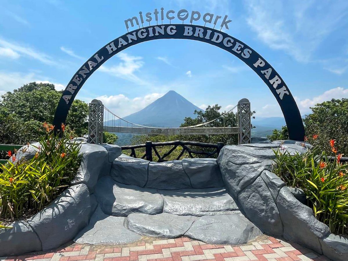 Entrance sign to Mistico Arenal Hanging Bridges Park in La Fortuna, Costa Rica, with Arenal Volcano in the background