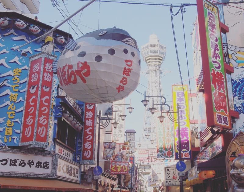 walking a vibrant street in Shinsaikei, Osaka while traveling alone in Asia
