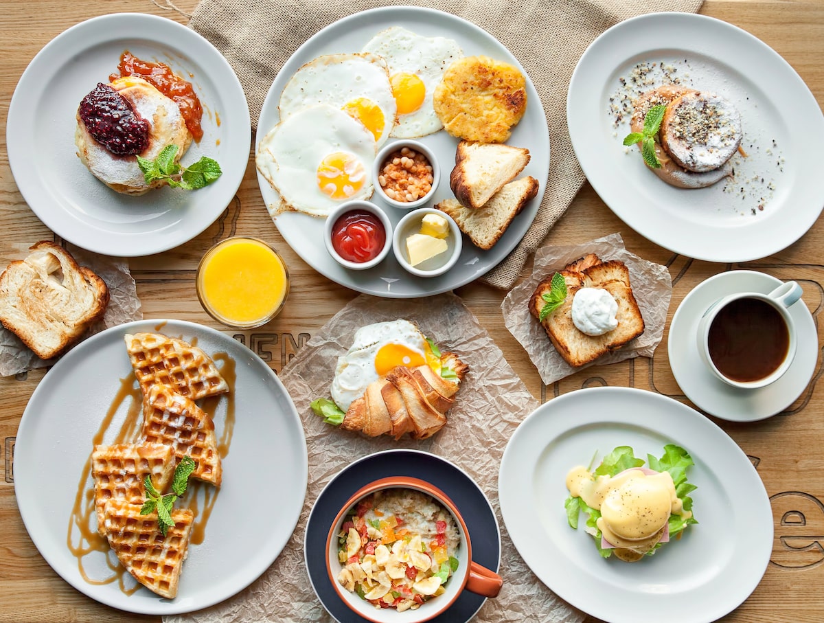 a delicious NYC brunch spread with waffles, eggs, croissants, coffee, and mimosas